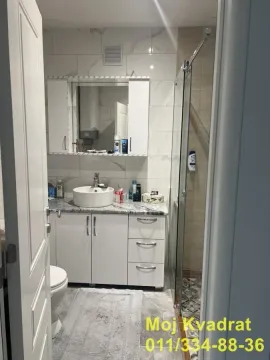 Pogled na moderno opremljeno kupatilo sa umivaonikom i tuš kabinom. - image 9
