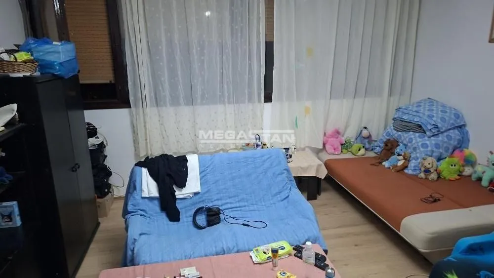 Nameštena spavaća soba sa krevetom i kaučem.