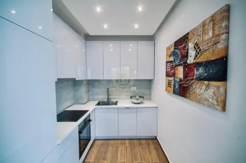Modern white kitchen with built-in appliances and a decorative painting on the wall. - image 5