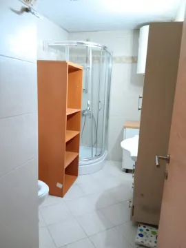 Small bathroom with a shower cabin, washbasin, and cabinet. - image 11