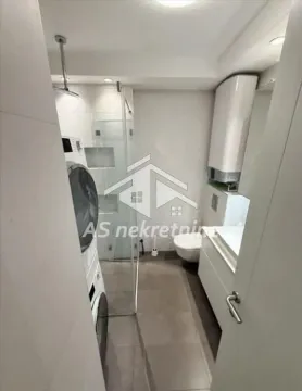 Savremeno opremljeno kupatilo sa tuš kabinom, umivaonikom i veš mašinom. - image 6