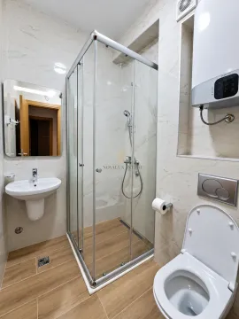 Modern bathroom with a shower cabin, washbasin, and toilet. - image 6