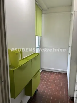 Zastakljeni balkon sa zelenim cipelarnikom i pločicama na podu. - image 9