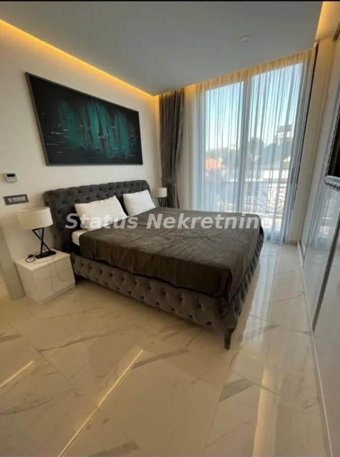 Modern bedroom with a double bed, large window and built-in wardrobe.
