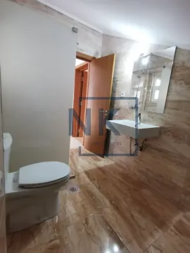 Tiled bathroom with a washbasin and a toilet. - image 4