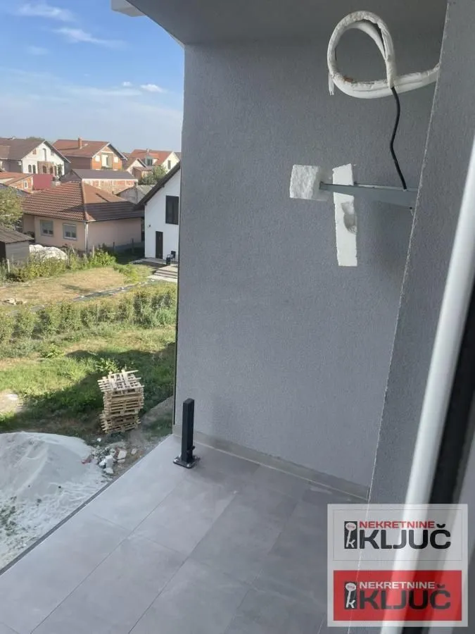 Pogled sa balkona na naselje i dvorište.