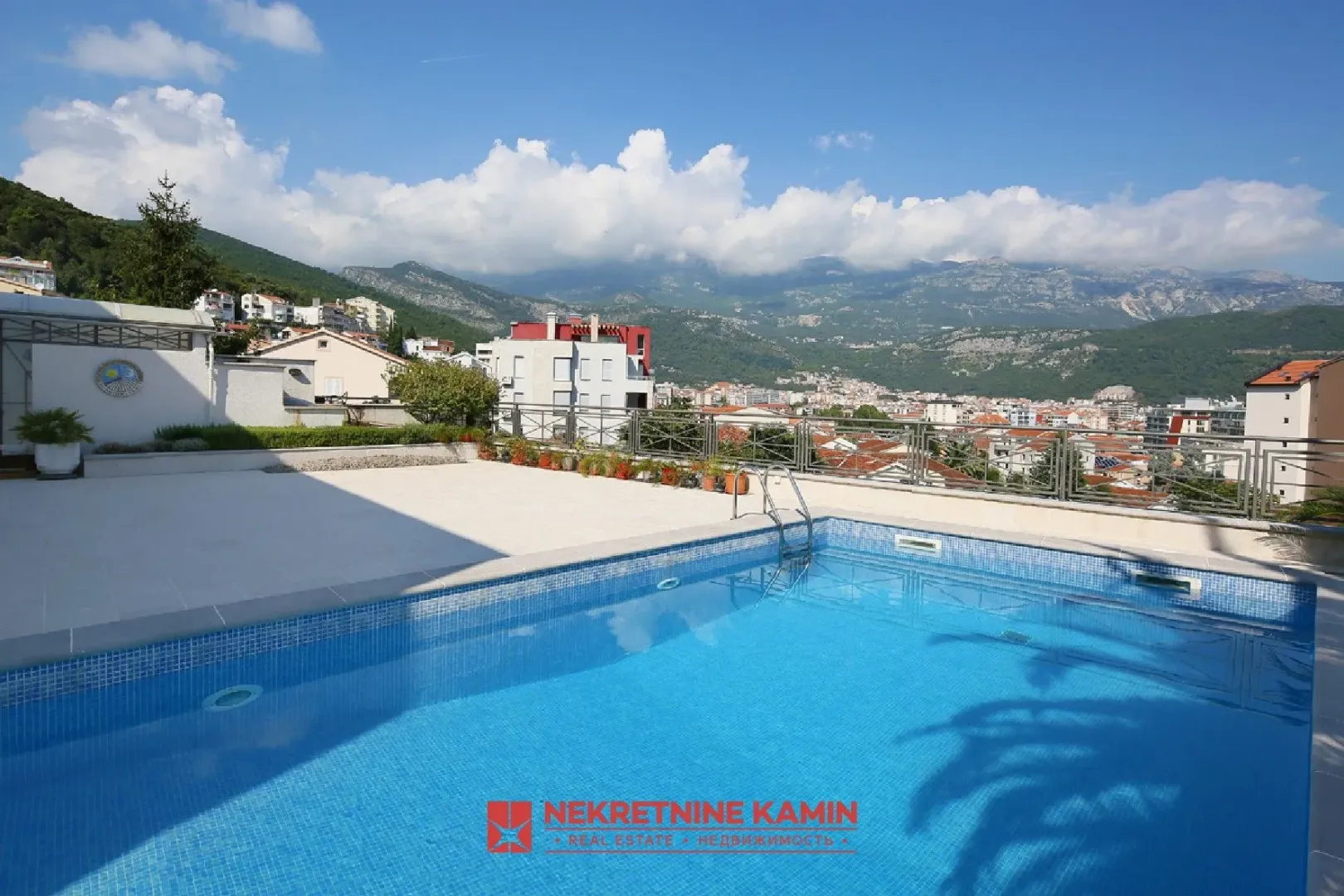 Swimming pool on the terrace with a view of the city and mountains.