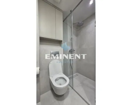 A modern bathroom equipped with a walk-in shower and built-in storage. - image 11