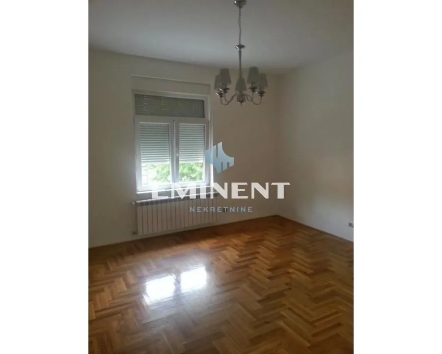 Empty room with parquet flooring and a chandelier on the ceiling.