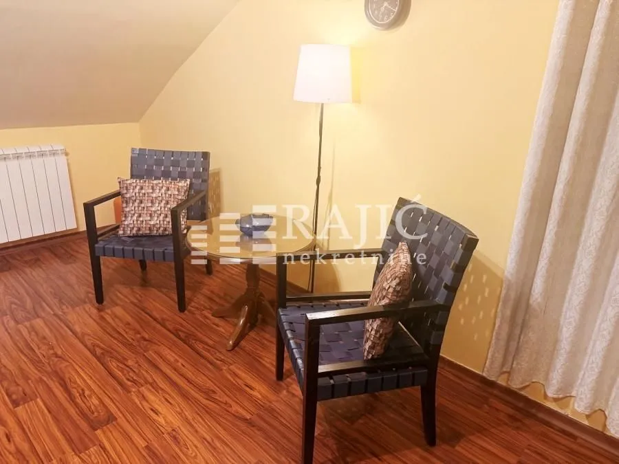 Living room with two armchairs, a small table, and a lamp.