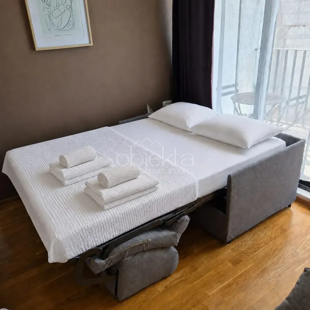 Furnished bedroom with a bed and neatly folded towels.