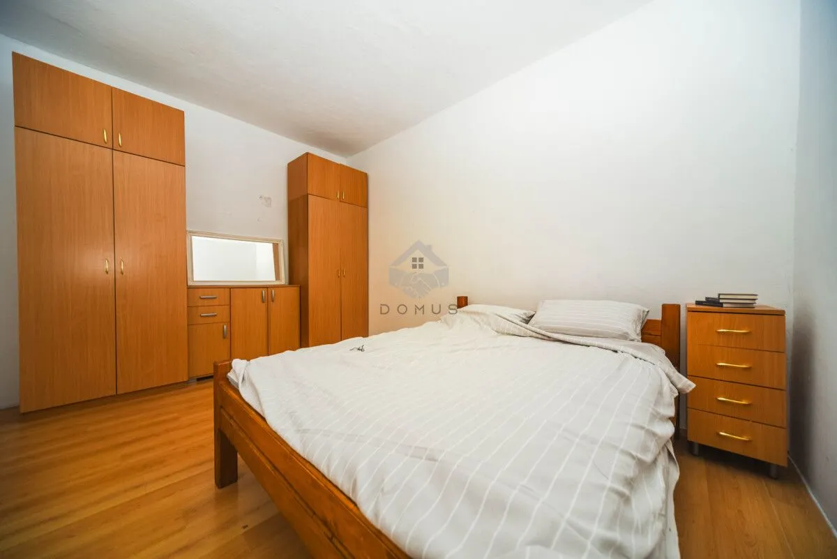 Bedroom with a double bed, wooden wardrobes, and a nightstand.
