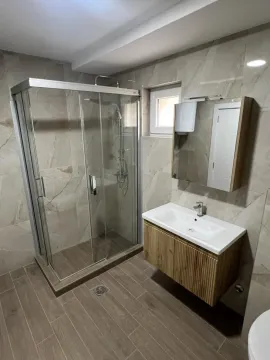 Savremeno opremljeno kupatilo sa tuš kabinom i umivaonikom. - image 11