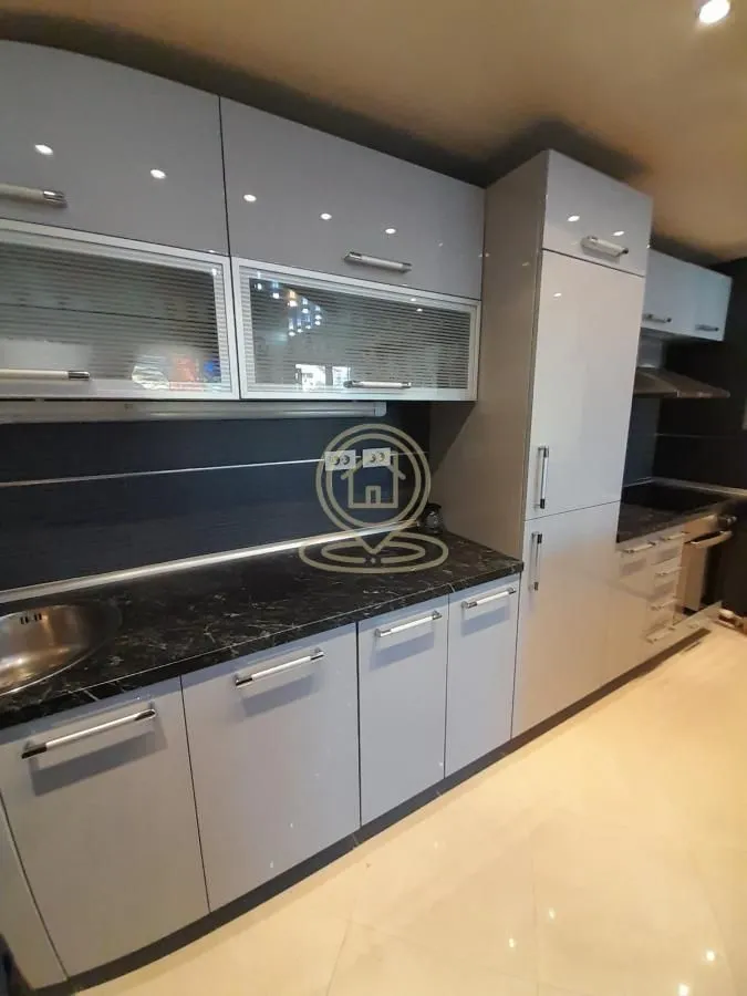 Modern kitchen with grey cabinets and built-in appliances.