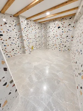Empty bathroom with terrazzo tiles and wooden ceiling beams. - image 4