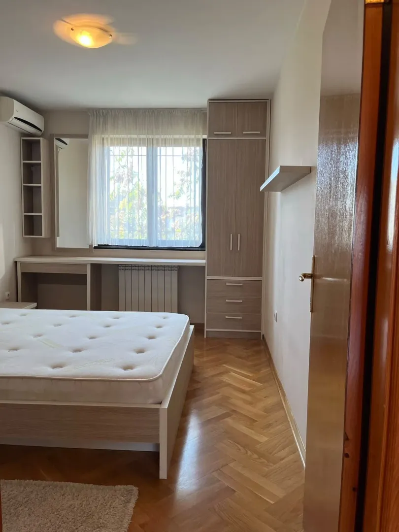 Namještena spavaća soba sa krevetom, garderoberom i radnim stolom.