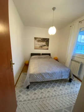 Uređena spavaća soba sa bračnim krevetom, tepihom i prozorom. - image 3