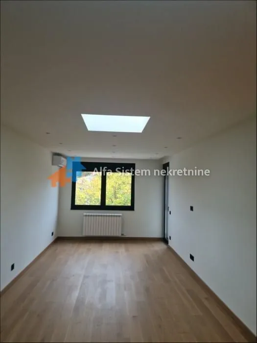 Empty room with parquet flooring and a window.