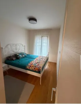 Spavaća soba sa bračnim krevetom i prozorom sa bijelim zavjesama. - image 3