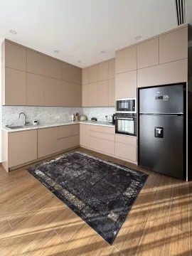 Modern kitchen with beige cabinets, built-in appliances, and a black refrigerator. - image 22