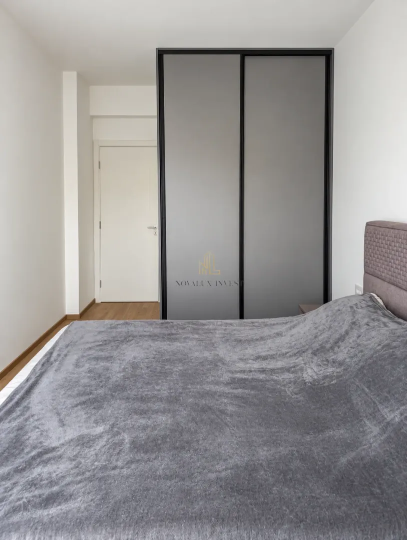Furnished bedroom with a double bed and built-in wardrobe.