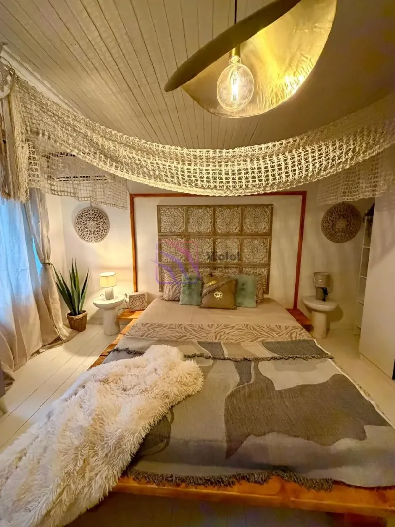 Furnished bedroom with a double bed and decorative elements on the ceiling.