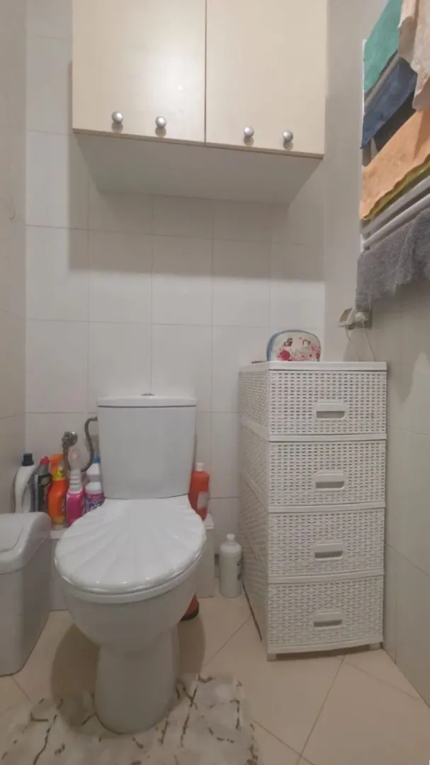 Manje kupatilo sa toaletom, ormarićem i visećim elementom.