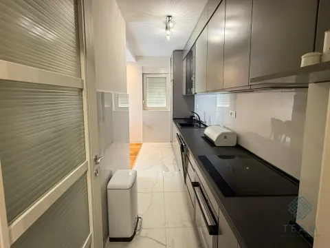 Modern narrow kitchen with dark cabinets and white floor tiles. - image 5