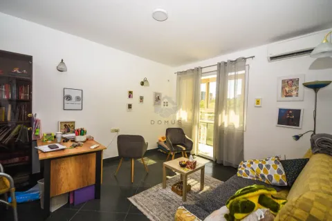 Living room with a desk, sofa, and balcony access. - image 3
