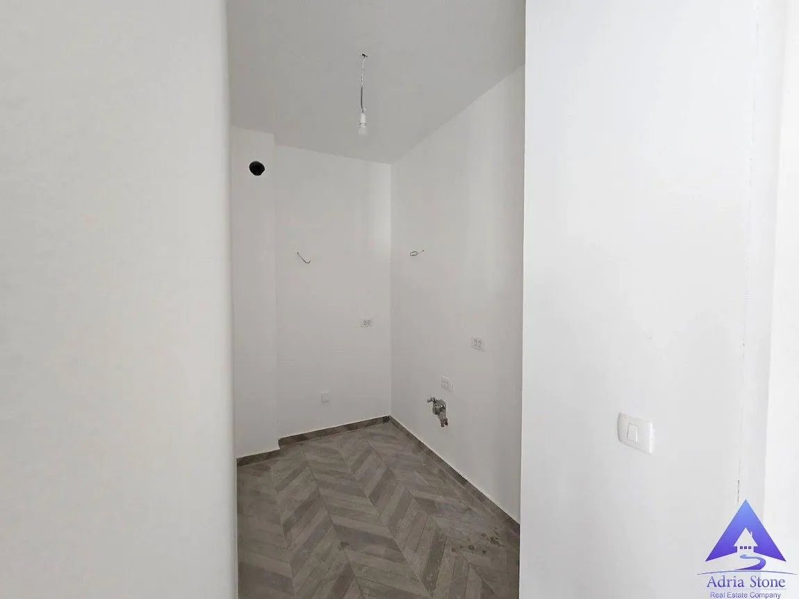 Prazna prostorija sa bijelim zidovima i pločicama na podu.