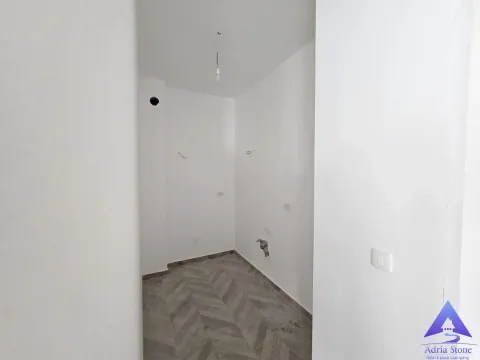 Prazna prostorija sa bijelim zidovima i pločicama na podu. - image 6