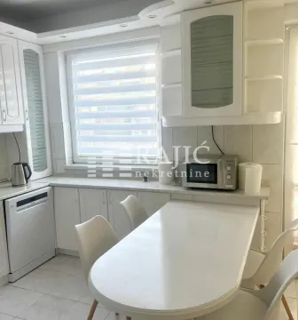 White kitchen with a dining table and chairs. - image 16