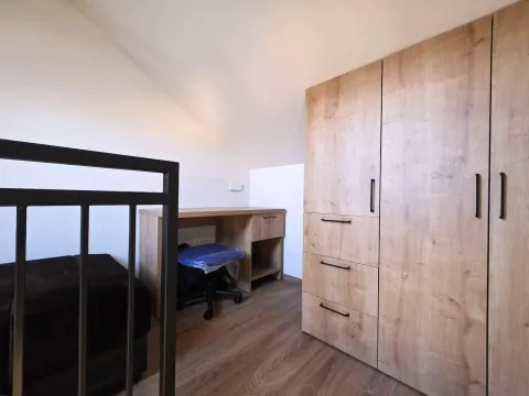 Manja spavaća soba sa velikim drvenim ormarom, radnim stolom i krevetom. - image 11