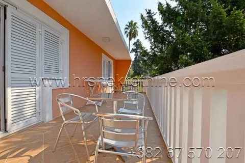 Spacious terrace with patio furniture and a view of greenery. - image 2
