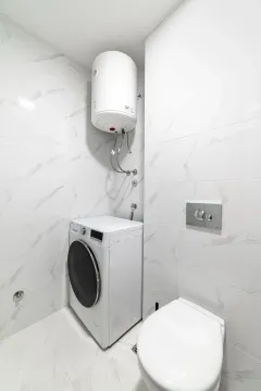 Moderno opremljeno kupatilo sa veš mašinom i ugradnim bojlerom. - image 15