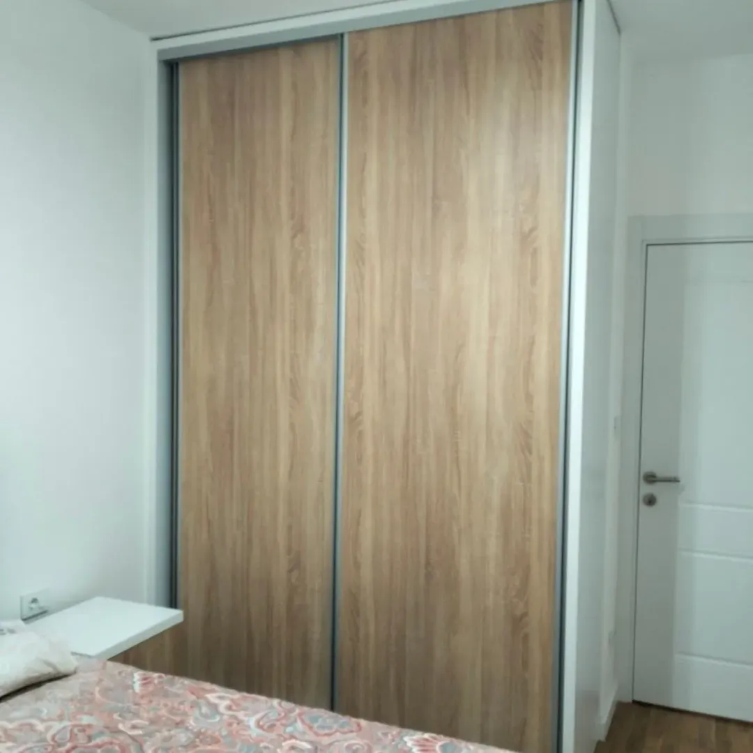 A bedroom featuring a built-in wardrobe with sliding wooden doors.