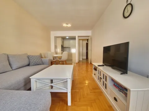 Living room with sofa, coffee table and television, looking towards the dining area and kitchen. - image 25