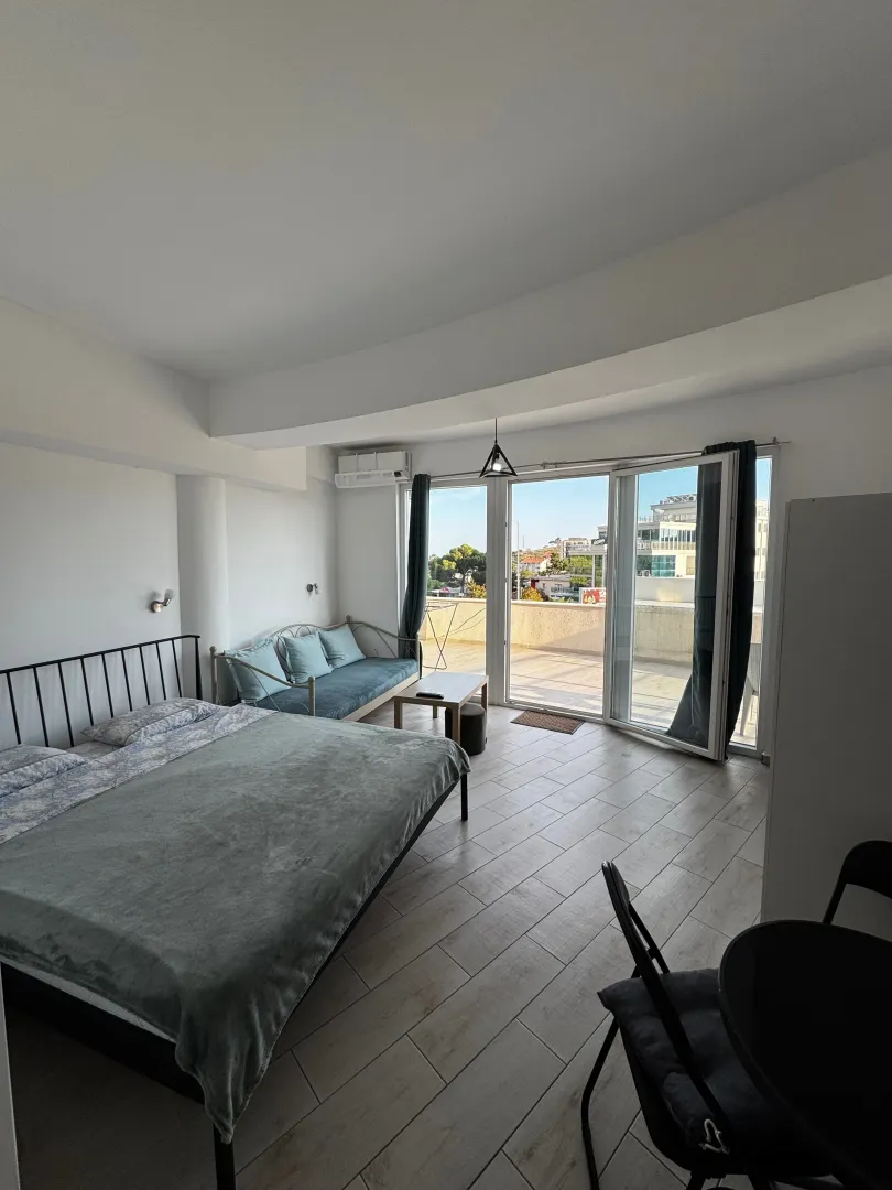 Spacious bedroom with a double bed, sofa, and access to the terrace.