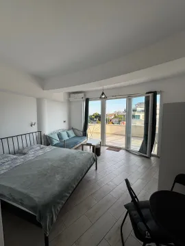 Spacious bedroom with a double bed, sofa, and access to the terrace. - image 10