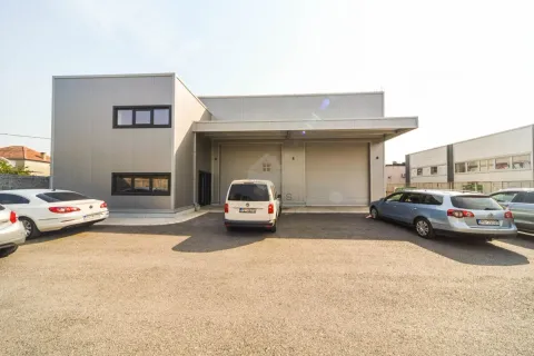 View of the exterior of the commercial building with a warehouse and parking in front. - image 2