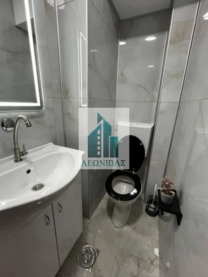 Modernly equipped bathroom with a washbasin and toilet.