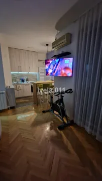 Dnevni boravak sa televizorom i kuhinjom u pozadini. - image 2