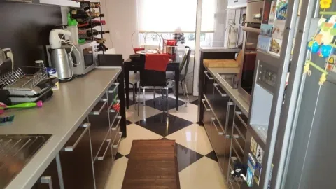 A kitchen with dark cabinets, a dining table, and black and white tiles. - image 4