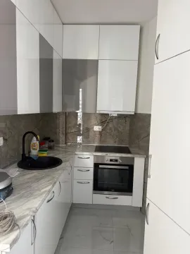 Manja moderna kuhinja sa bijelim elementima i ugrađenom rernom. - image 2