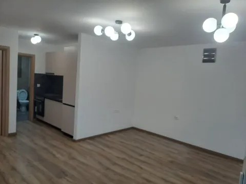Empty living room with laminate flooring and a view of the kitchen. - image 5