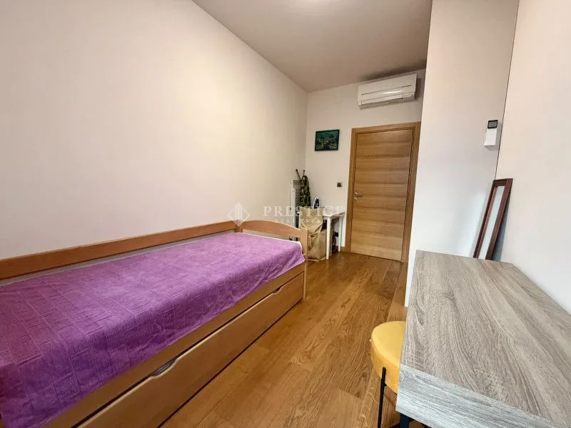 Smaller bedroom with a bed and wooden flooring.