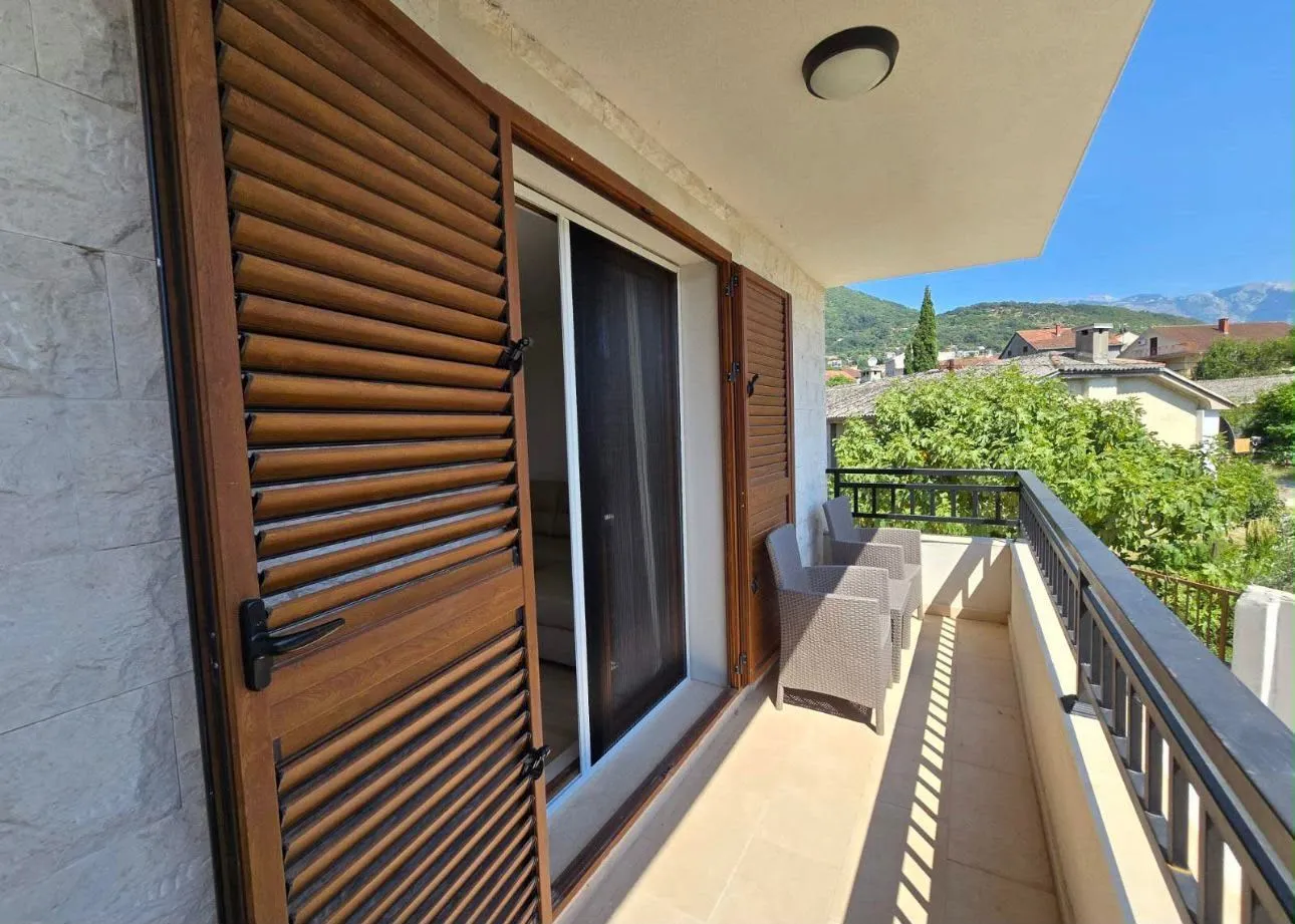 Prostrana terasa sa drvenim kapcima i garniturom za sjedenje.