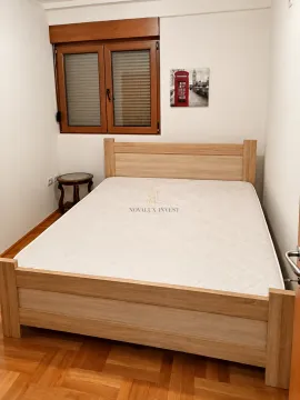 Bedroom with a wooden bed and a window. - image 7