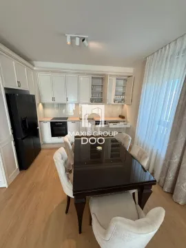 Kitchen with white cabinetry and a black refrigerator, combined with a dining area. - image 6