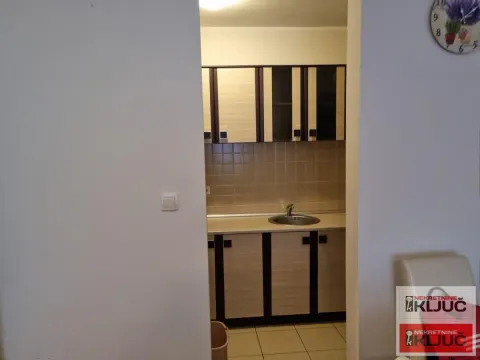 Pogled iz hodnika na manju kuhinju sa drvenim elementima. - image 5